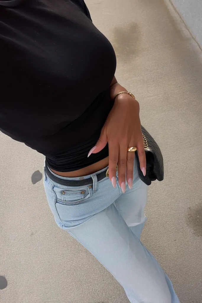 Trendy casual fall outfits for women, effortless chic aesthetic with black top with high-rise light blue jeans, black designer bag for refined weather style