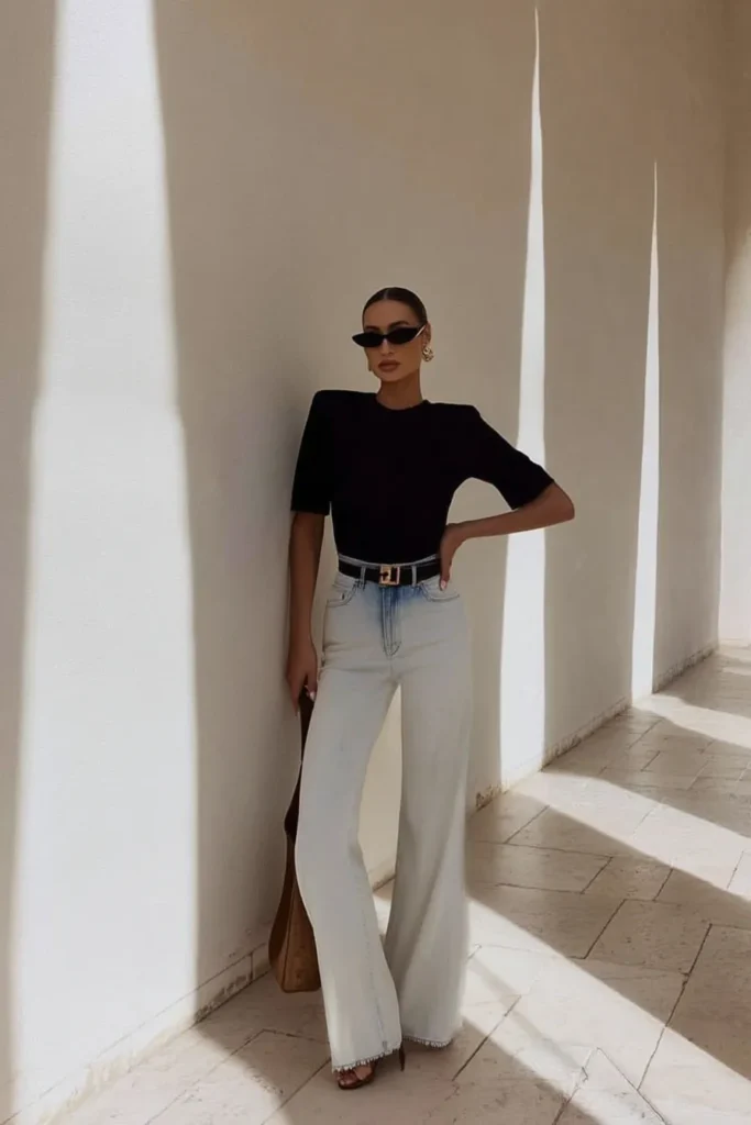 Trendy fall outfits, chic minimalist ensemble with black short-sleeve crew neck top tucked into light wash high-waisted wide-leg jeans, with black sunglasses and for effortless autumn styling