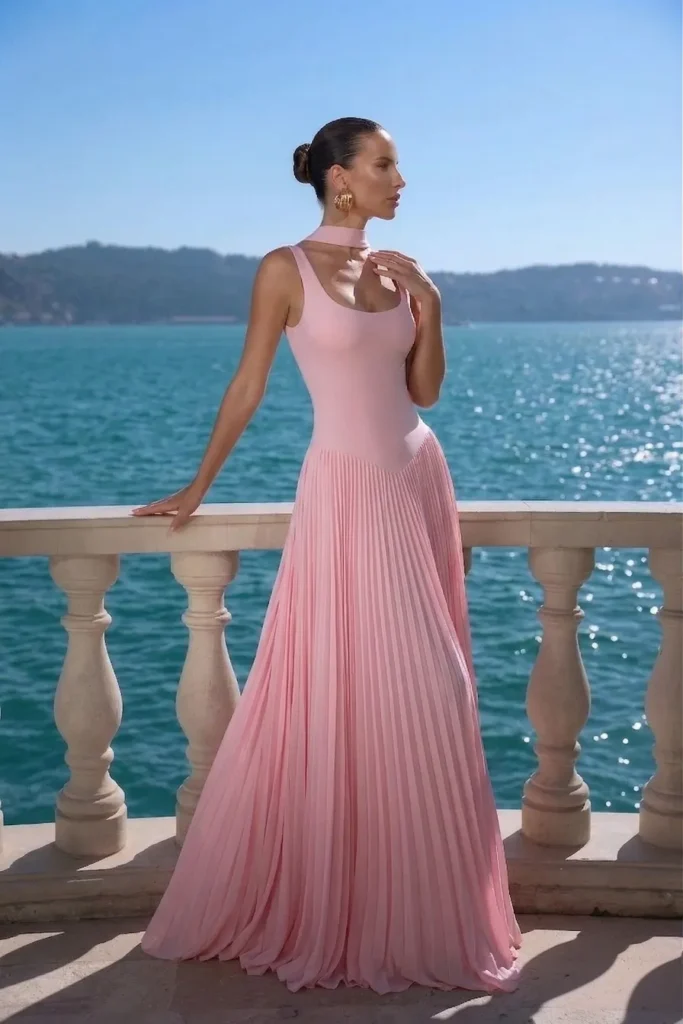 Chic light pink spring wedding guest dress, sleeveless dress with pleated floor-sweeping skirt, accessorized with statement silver cuff bracelet for formal look